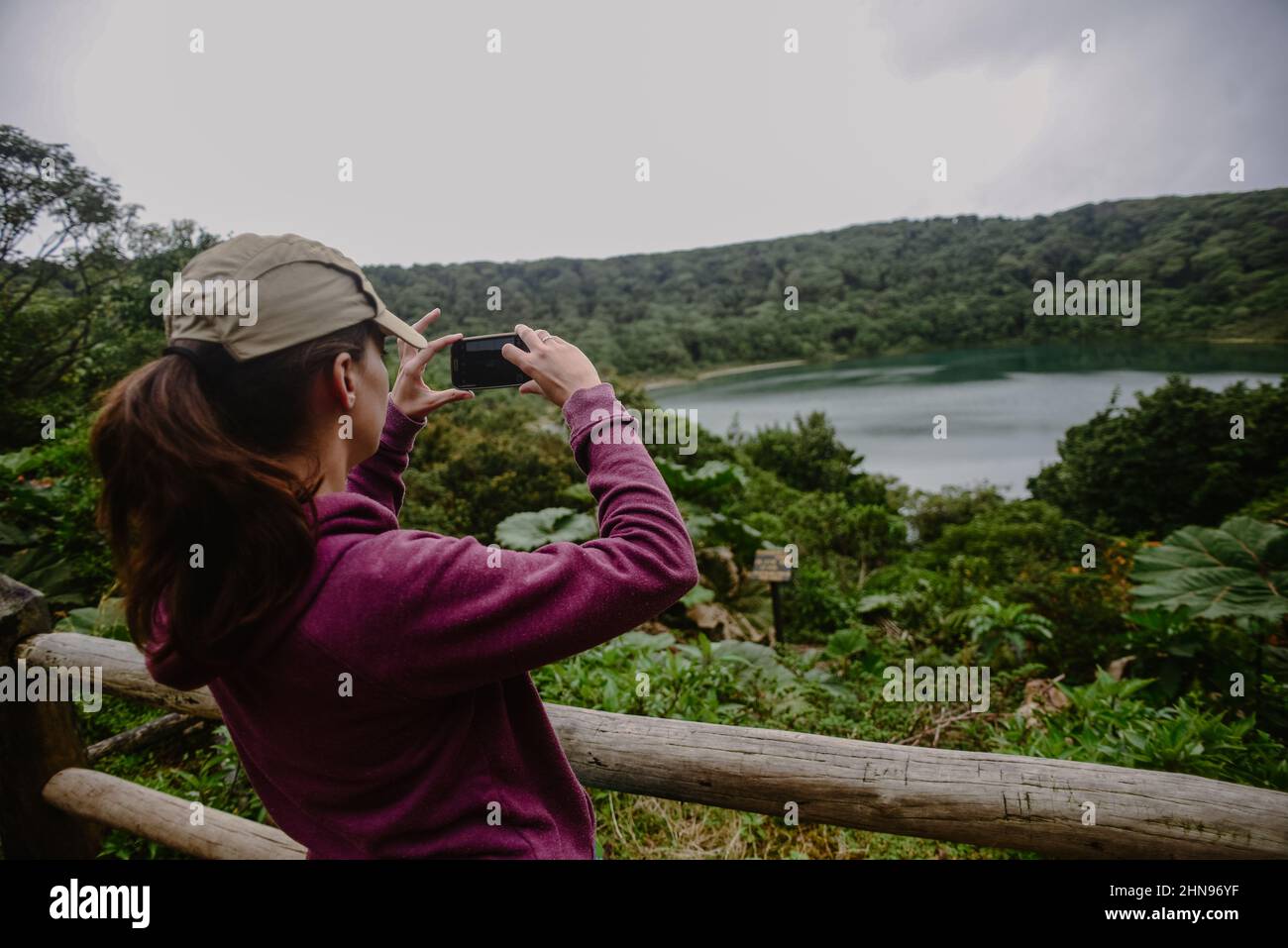 Jeune femme photographiant le lac Botos, un cratère inactif situé dans le parc national du volcan Poas, au Costa Rica Banque D'Images