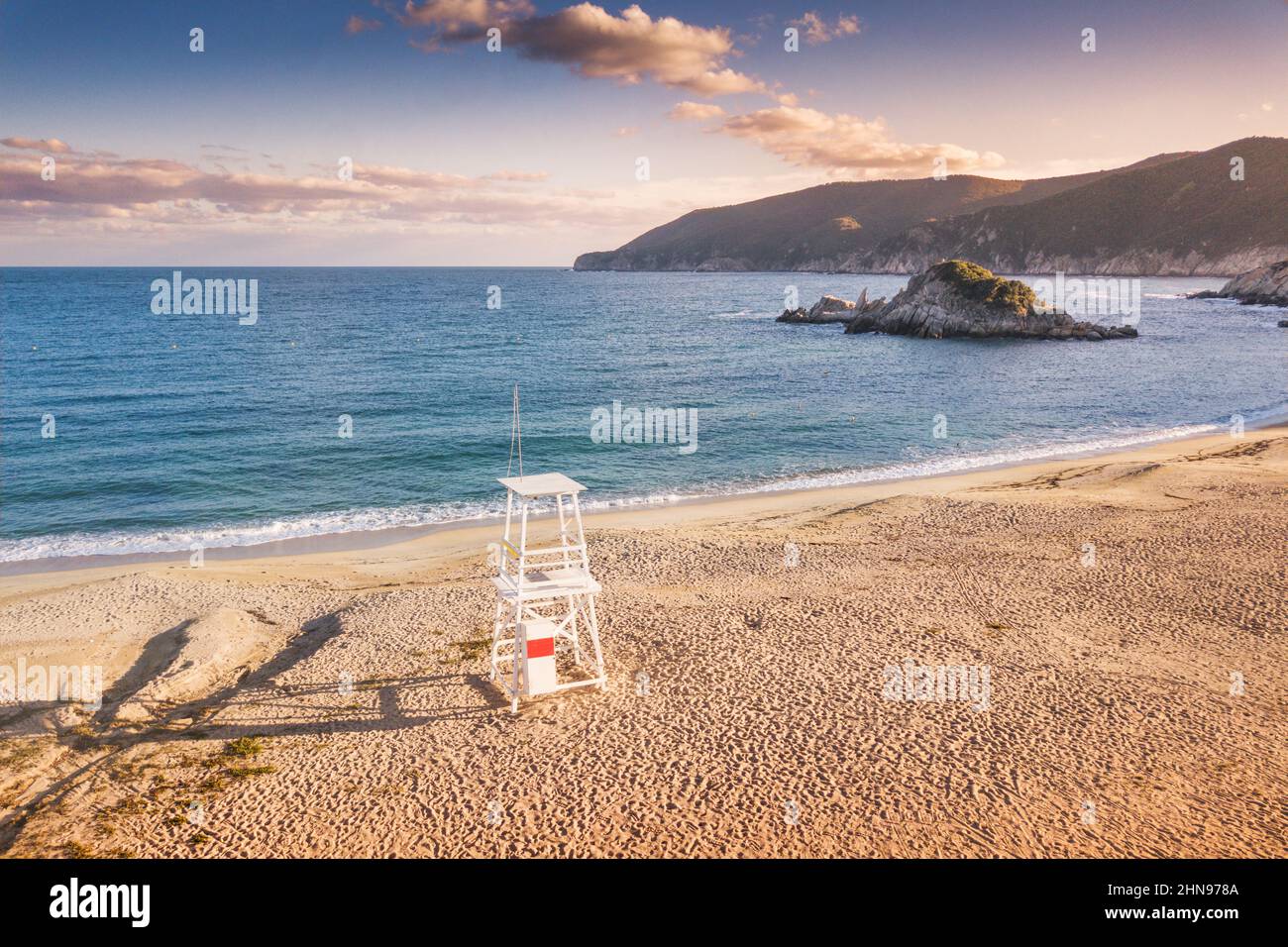 Une tour de maître-nageur sur la plage de sable vide de Kalamitsi en Grèce au coucher du soleil coloré Banque D'Images