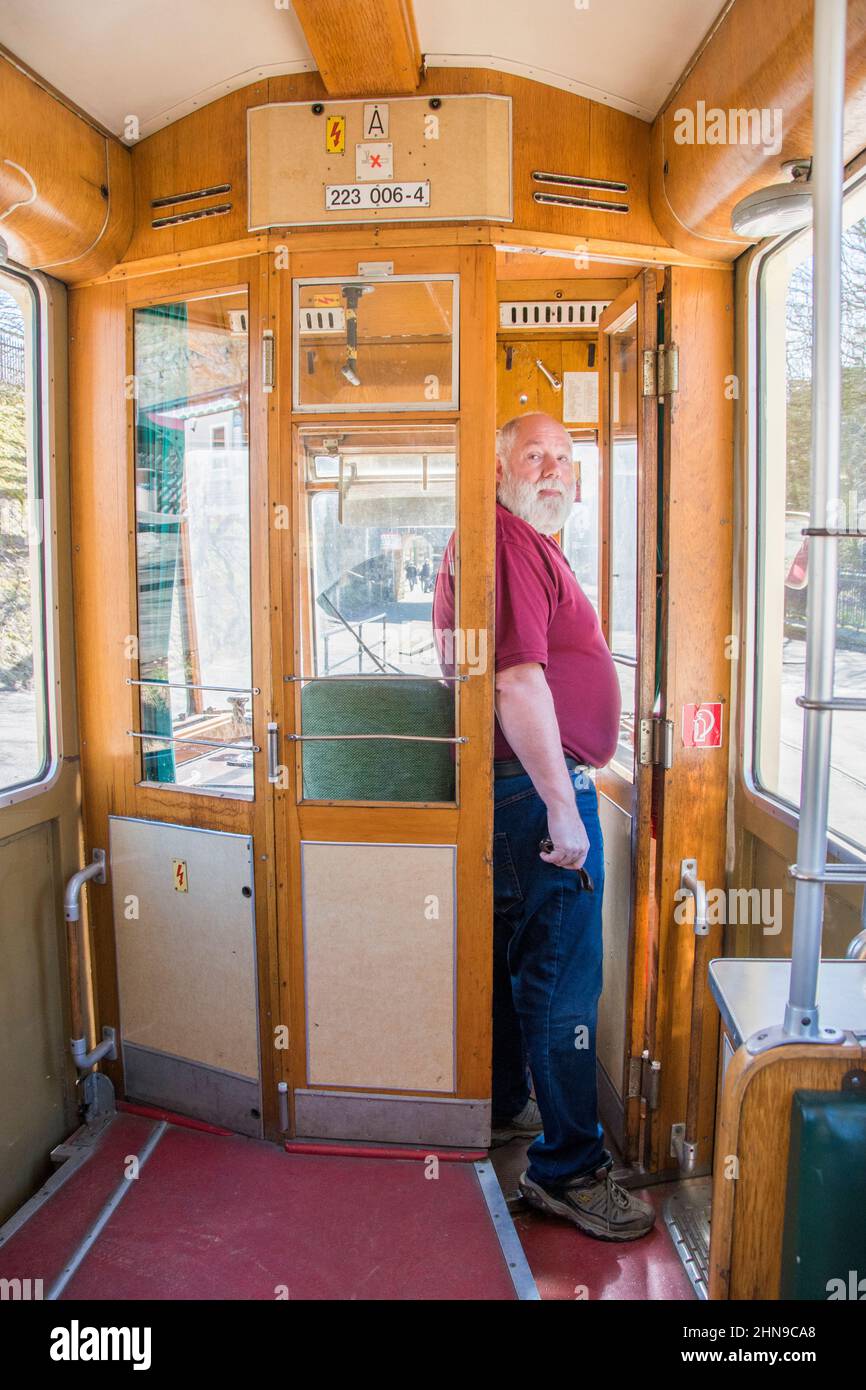 Derbyshire, Royaume-Uni – 5 avril 2018 : un chauffeur de tramway pose à la porte du taxi d'un ancien tramway au musée national du tramway du village de Crich Banque D'Images