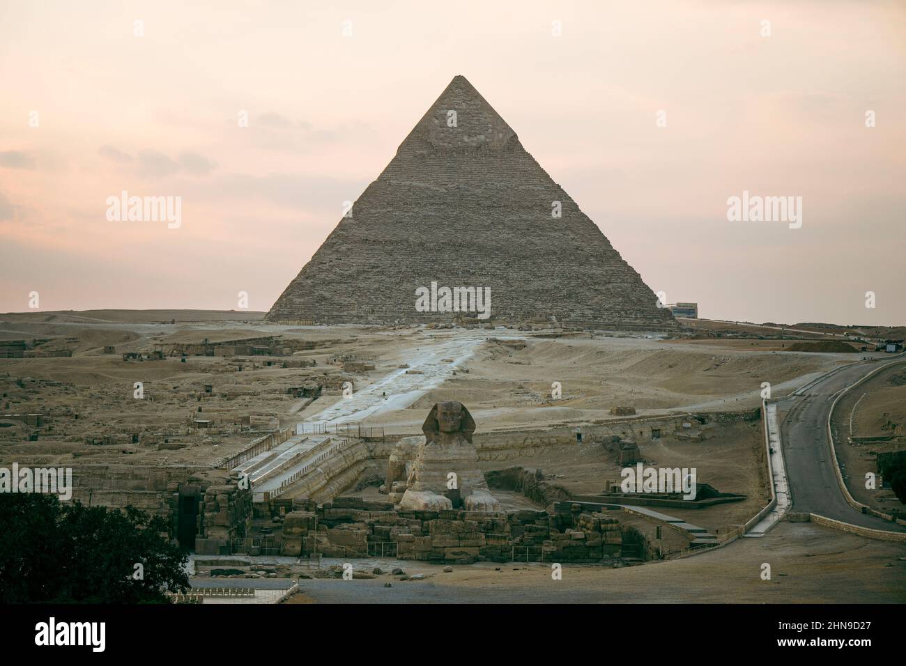 Superbe sphinx et pyramides sous un soleil éclatant. Vue sur le plateau de Gizeh avec les grandes pyramides et le sphinx le soir au coucher du soleil Banque D'Images