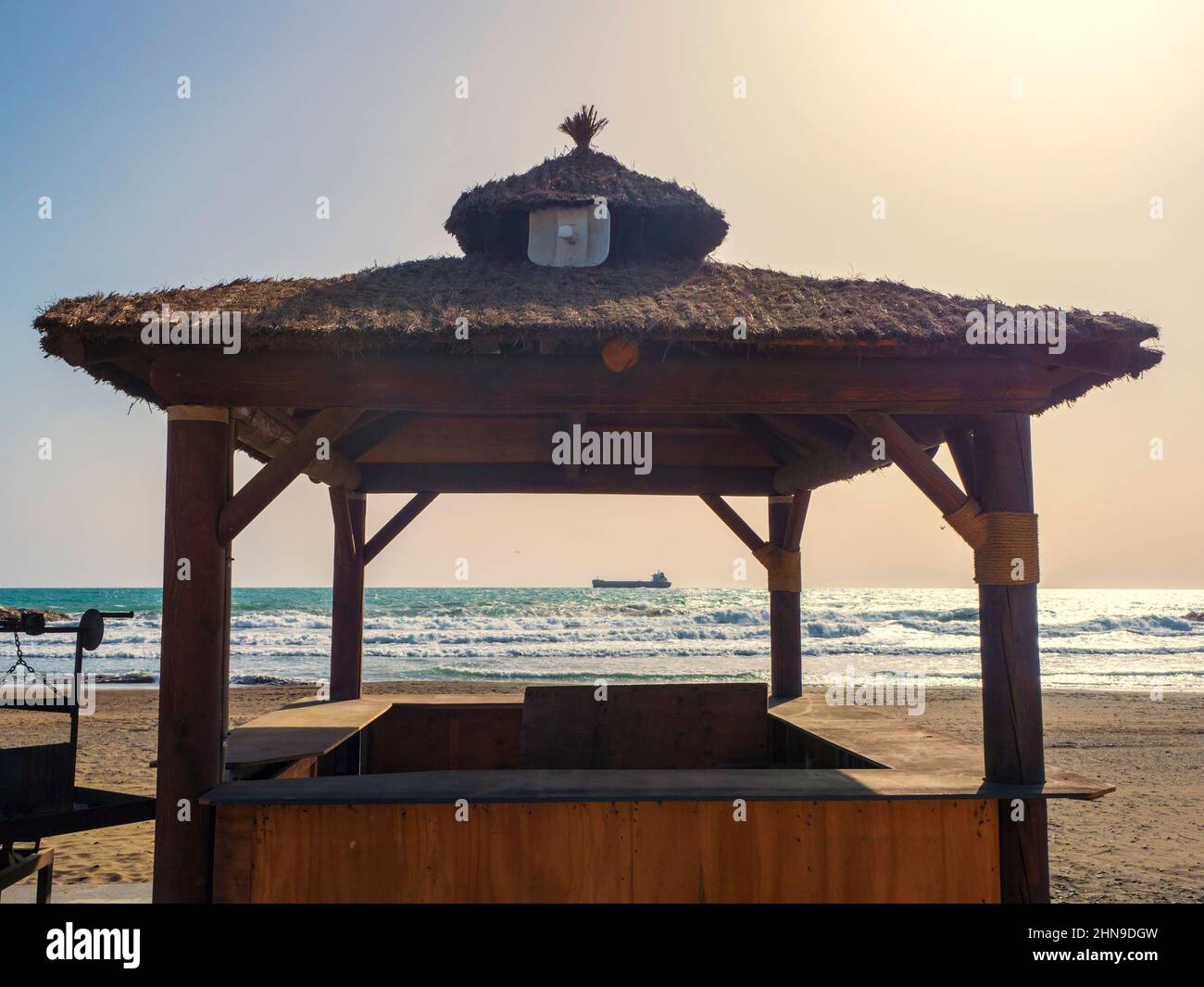 Silhouette de toit en bois avec barbecue en face de la mer Banque D'Images