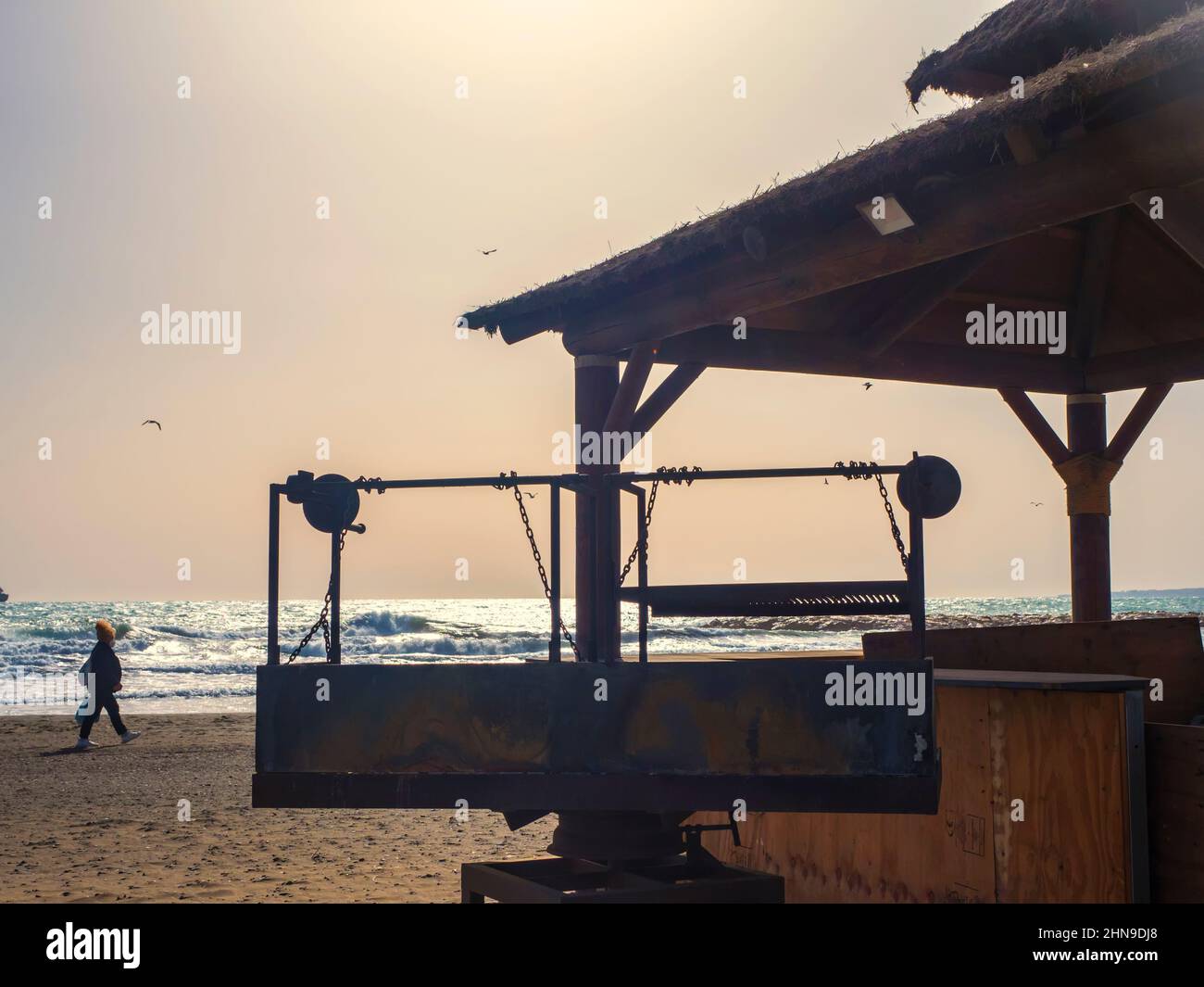 Silhouette de toit en bois avec barbecue en face de la mer Banque D'Images