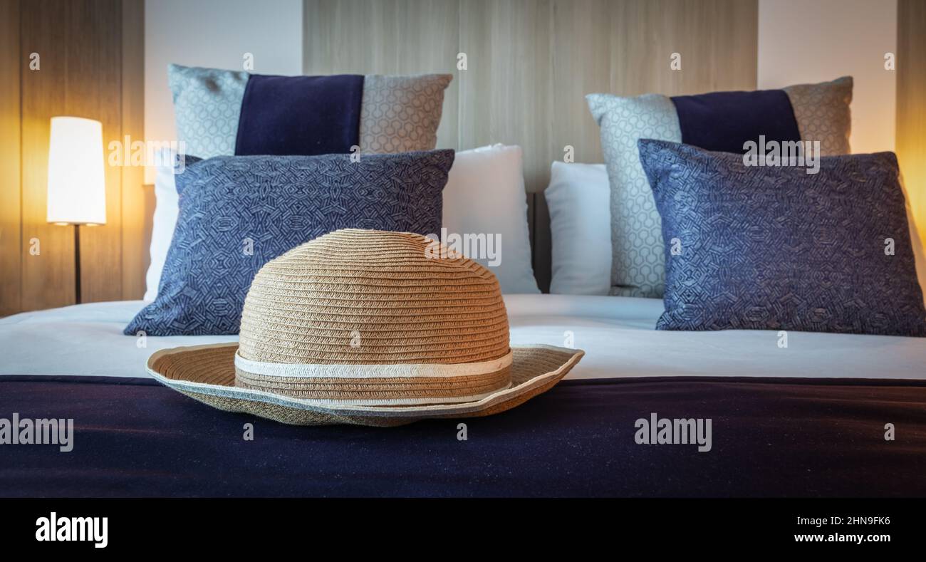 Chapeau d'été sur un lit de luxe. Concept de voyage et de vacances. Banque D'Images