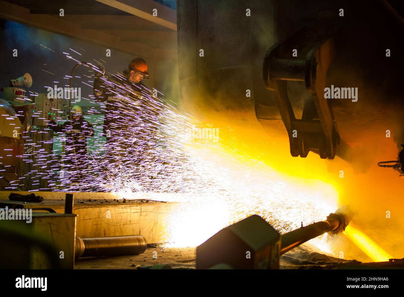 Temirtau, Kazakhstan - 08 juin 2012 : usine de métallurgie d'Arcelor Mittal. Fabrication de l'acier. Travailleur nourrissant l'oxygène pour fondre. Étincelles et incendie. Banque D'Images