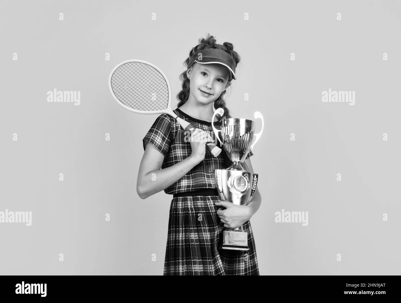 bonne fille tenant des équipements de sport. raquette de tennis pour enfant. enfant portant une casquette de fitness. activité d'enfance. mode de vie sain. soyez énergique. badminton Banque D'Images