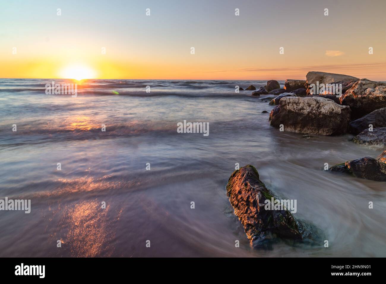 Vue large à angle bas des vagues qui s'écrasant sur les rochers au coucher du soleil sur la mer Poleg Beach Israël. Banque D'Images