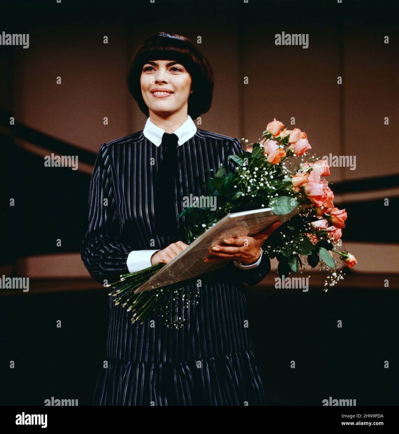 Der Große Preis, ZDF Quizshow, Musikalischer Gast: Mireille Mathieu, auf dem Bild mit Blumenstrauß, 1981. Der grosse Preis, ZDF Quiz show, invité: La chanteuse française Mireille Mathieu, sur la photo avec bouquet, 1981. Banque D'Images