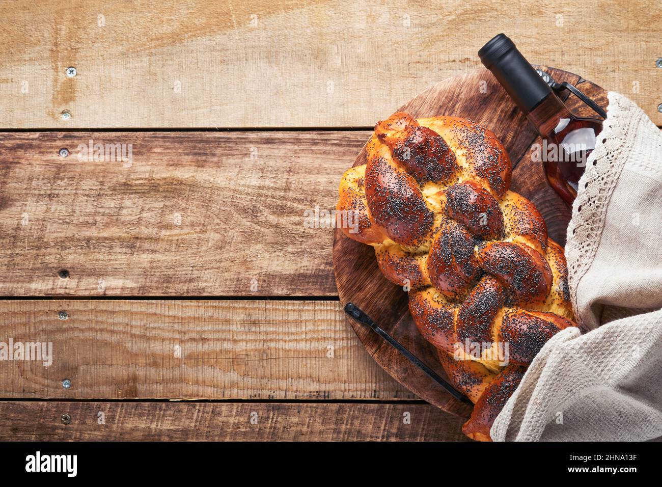 Shebbat Shalom. Gallah de pain aux graines de sésame et de pavot sur fond de bois. Pain juif traditionnel pour Shabbat et vacances. Décoration rustique Banque D'Images