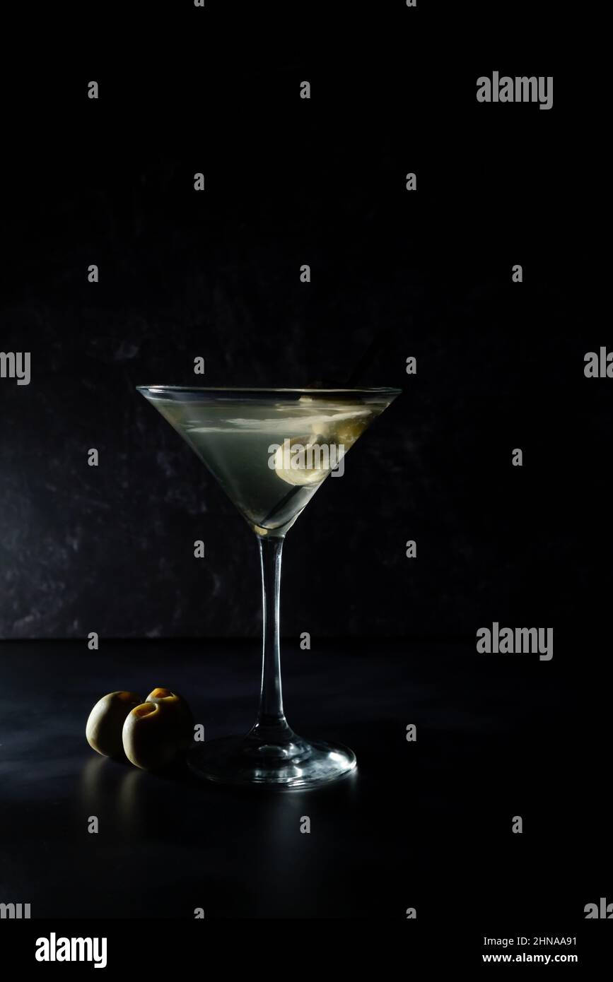 Martini sale avec des olives sur fond noir Banque D'Images