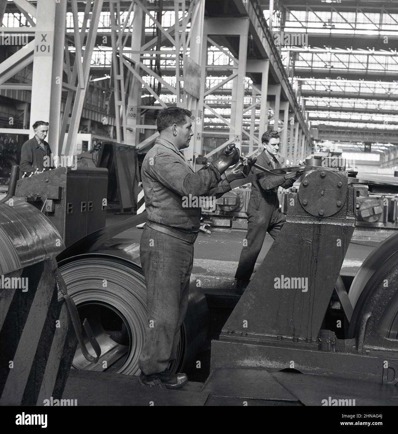 1950s, historique, travailleurs sur un plancher industriel usine de pressage de tôles d'acier laminées, Port Talbot, pays de Galles, Royaume-Uni. Banque D'Images