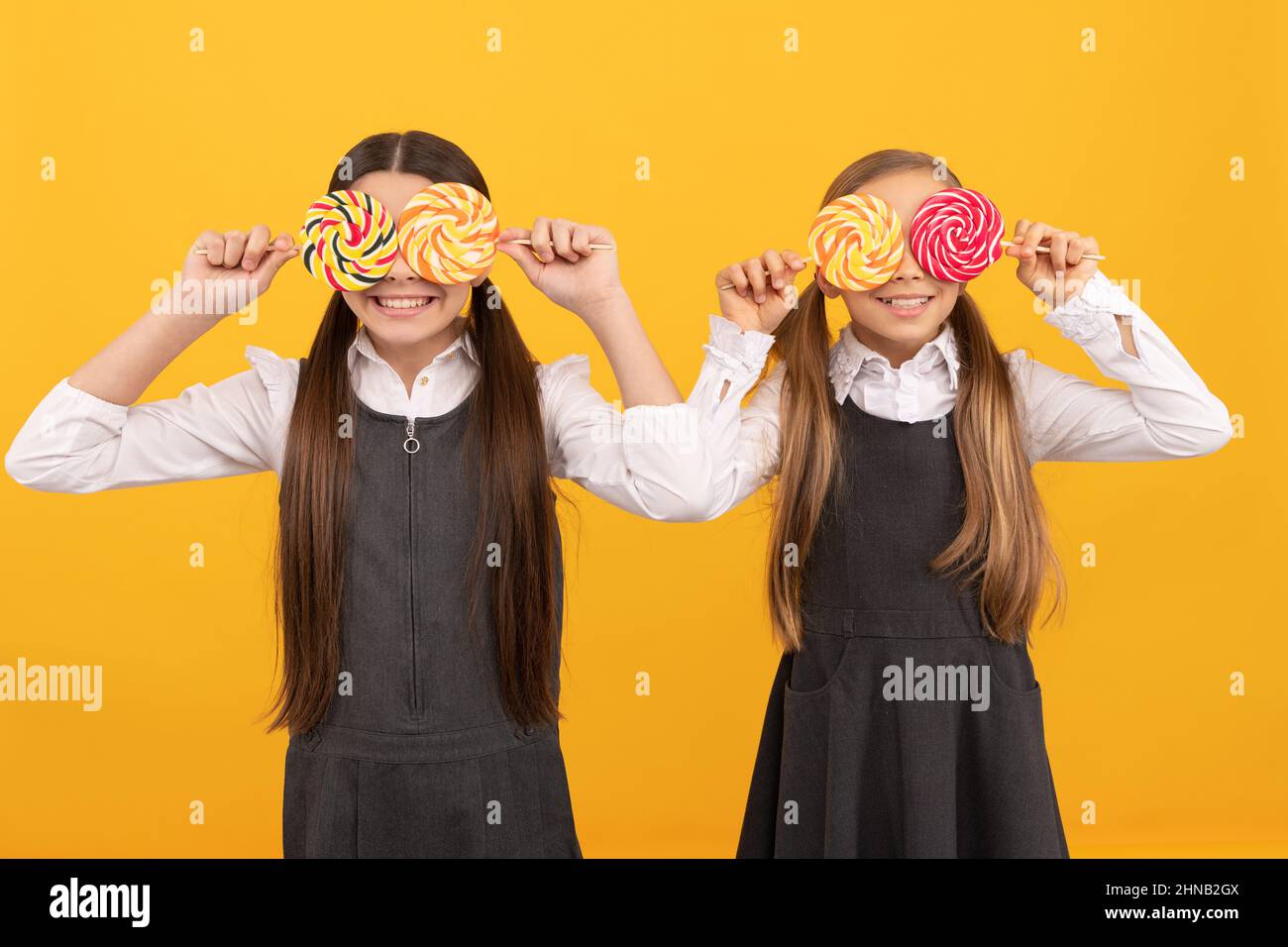 Look élégant. Les élèves amusants couvrent les yeux avec des sucettes. Éducation scolaire. Une vie toujours douce. Profitez-en aujourd'hui Banque D'Images