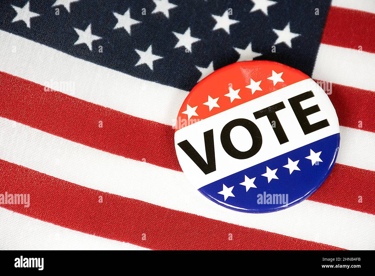 Gros plan d'un bouton de vote de campagne sur un drapeau américain Banque D'Images