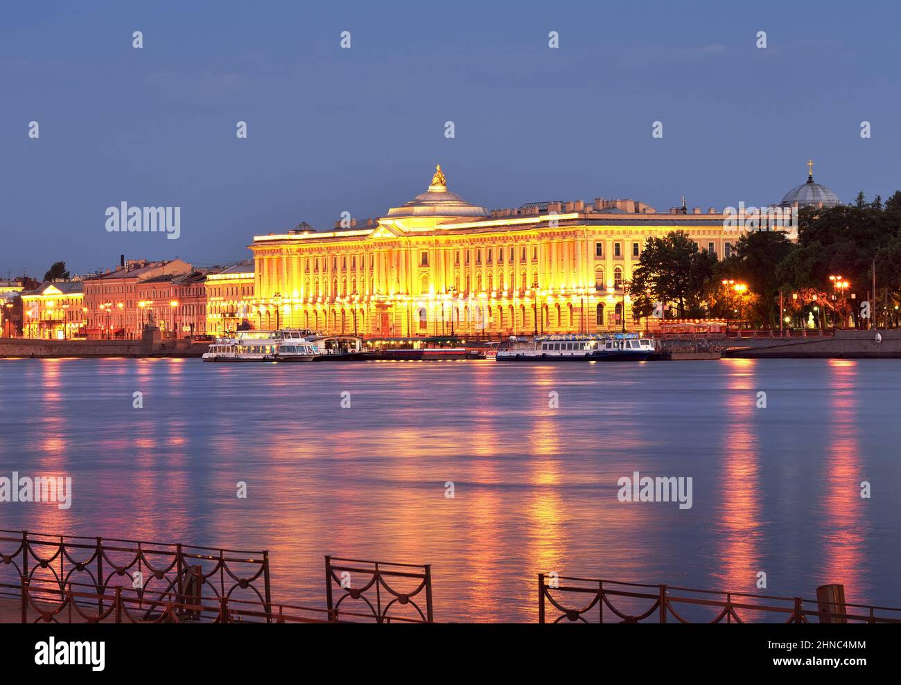 Saint-Pétersbourg, Russie, 09.01.2020. Académie impériale des arts dans les lumières de nuit. Remblai de l'université avant l'aube, reflets roses sur l'eau bleue. Banque D'Images