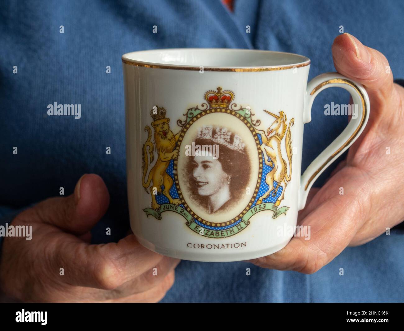 Mains de femme tenant une tasse à couronnement Queen Elizabeth II 1953, Royaume-Uni Banque D'Images