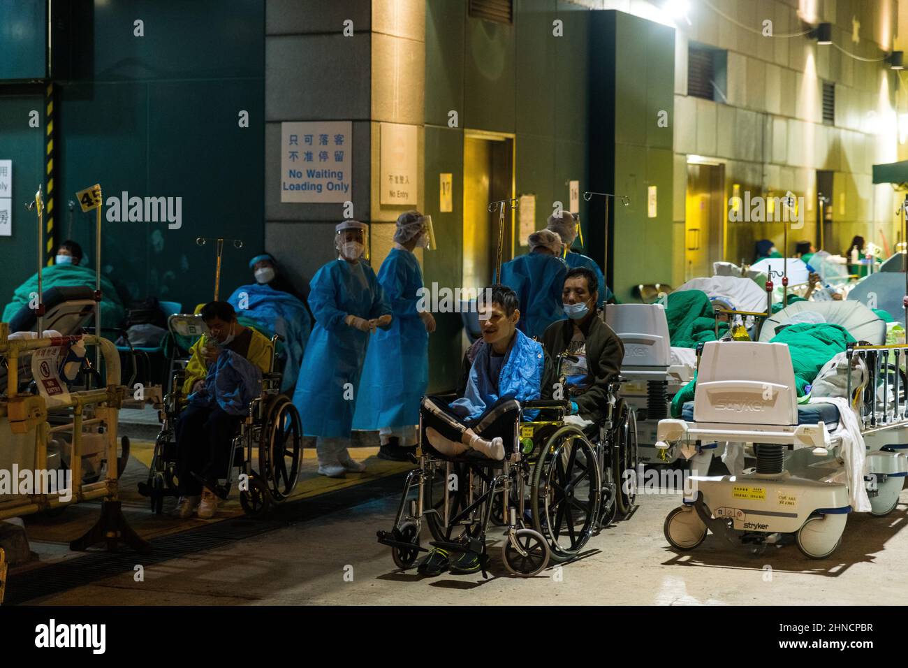 Hong Kong, Chine. 15th févr. 2022. Les patients souffrant d'un handicap mental de la COVID sont laissés en fauteuil roulant à l'extérieur au centre médical Caritas de Sam Shui po, à Hong Kong. Les patients ont dû être accueillis à l'extérieur, car les hôpitaux ont été submergés par l'épidémie d'omicron. Crédit : Marc R. Fernandes/Alamy Live News Banque D'Images