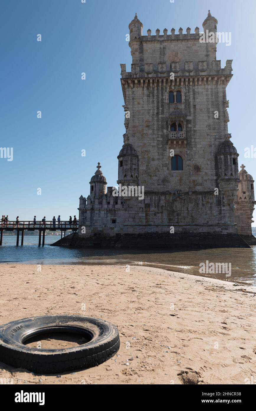Pneu de voiture d'occasion situé sur la rive du Tage en face de la tour historique de Belem (Torre de Belem). Lisbonne, Portugal Banque D'Images
