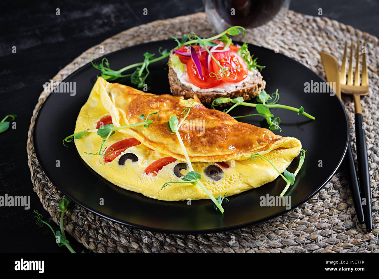 Petit déjeuner sain. Omelette aux tomates, au fromage et aux olives. Sandwich avec fromage à la crème et tomate. Banque D'Images