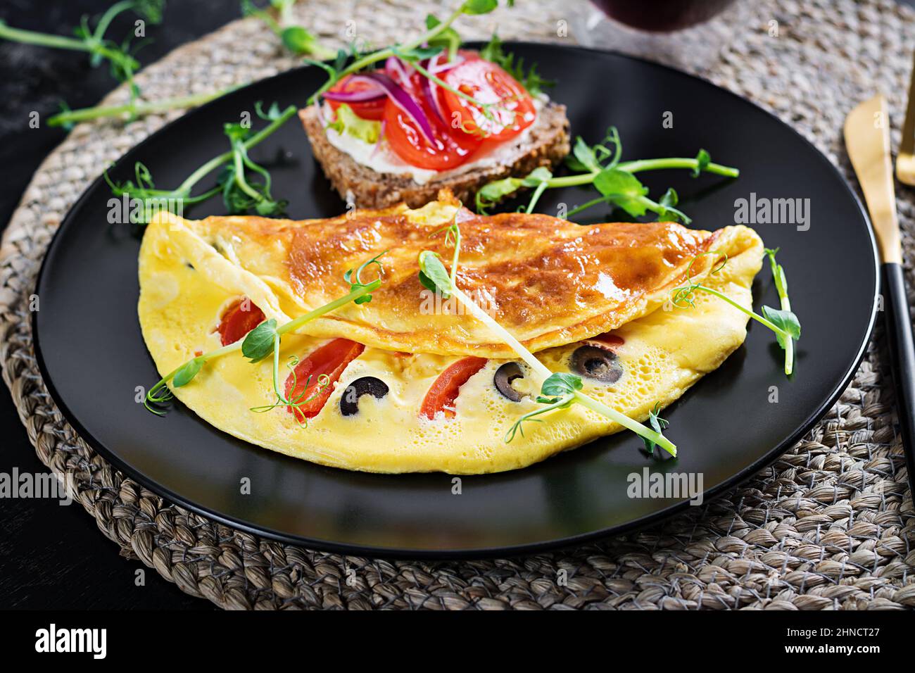 Petit déjeuner sain. Omelette aux tomates, au fromage et aux olives. Sandwich avec fromage à la crème et tomate. Banque D'Images