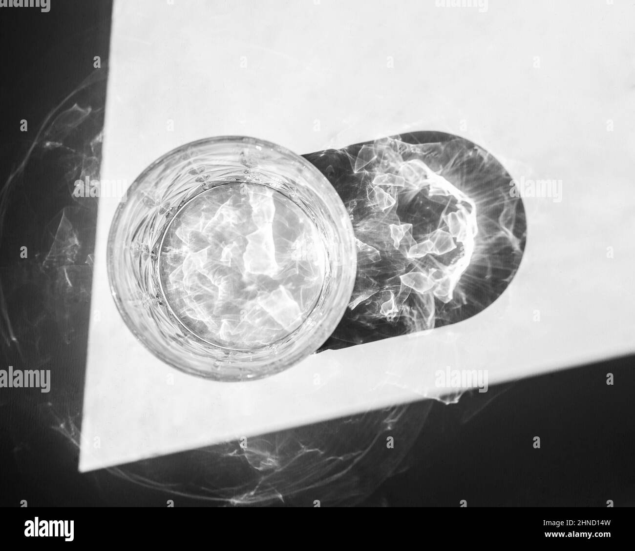 De dessus, verre à bille basse vide placé sur une table blanche près de l'ombre et réfléchissant la lumière du soleil en journée Banque D'Images