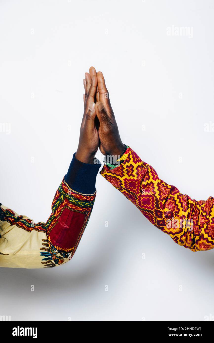 Gros plan d'un couple anonyme dans une tenue africaine branchée sur fond blanc en studio Banque D'Images