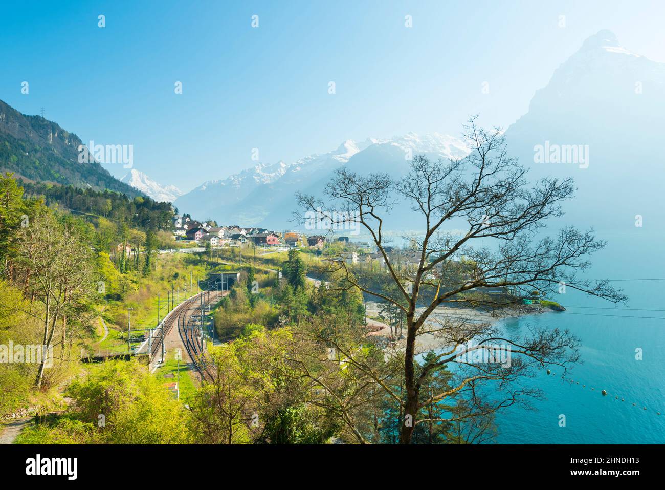 Vue sur la petite ville dans les montagnes des Alpes. Maisons traditionnelles. Chemin de fer le long du lac de Lucerne. Canton d'Uri. Banque D'Images