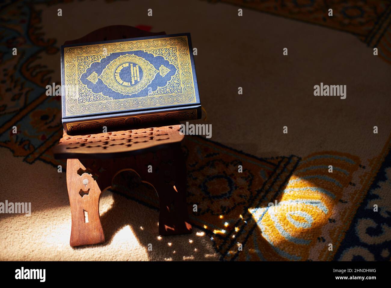 Une vie encore du Coran sur un stand à l'intérieur d'une mosquée baignée de lumière du soleil Banque D'Images