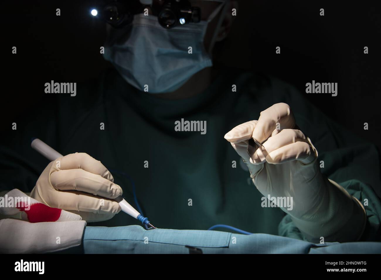 Portrait de la jeune femme chirurgien, portant un masque et un masque chirurgical, devant un fond noir. Banque D'Images