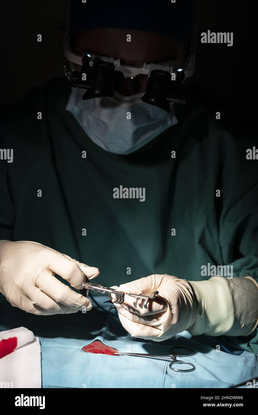 Portrait de la jeune femme chirurgien, portant un masque et un masque chirurgical, devant un fond noir. Banque D'Images