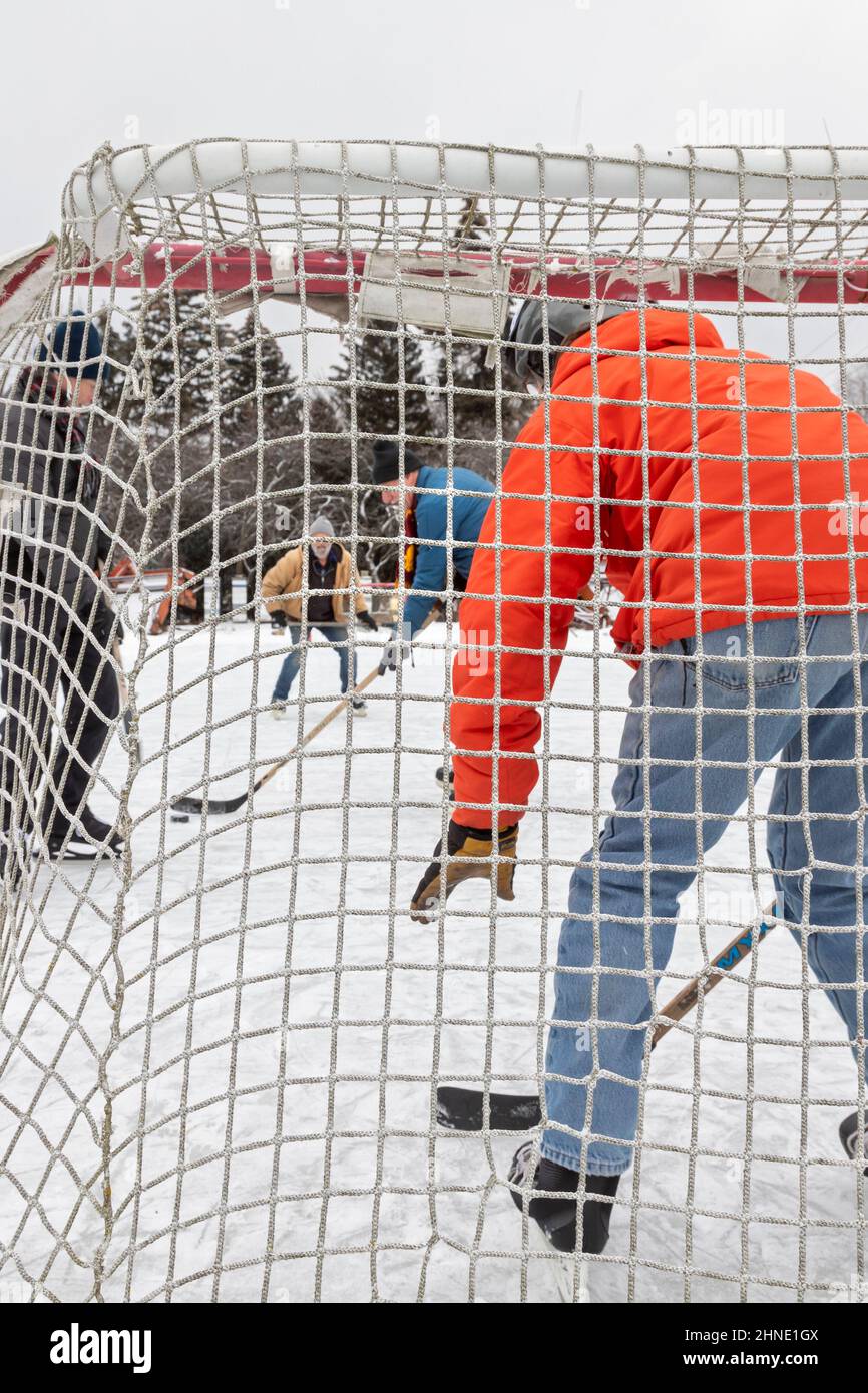 Detroit, Michigan - des hommes plus âgés jouent au hockey sur glace sur une patinoire de chantier improvisée. Banque D'Images