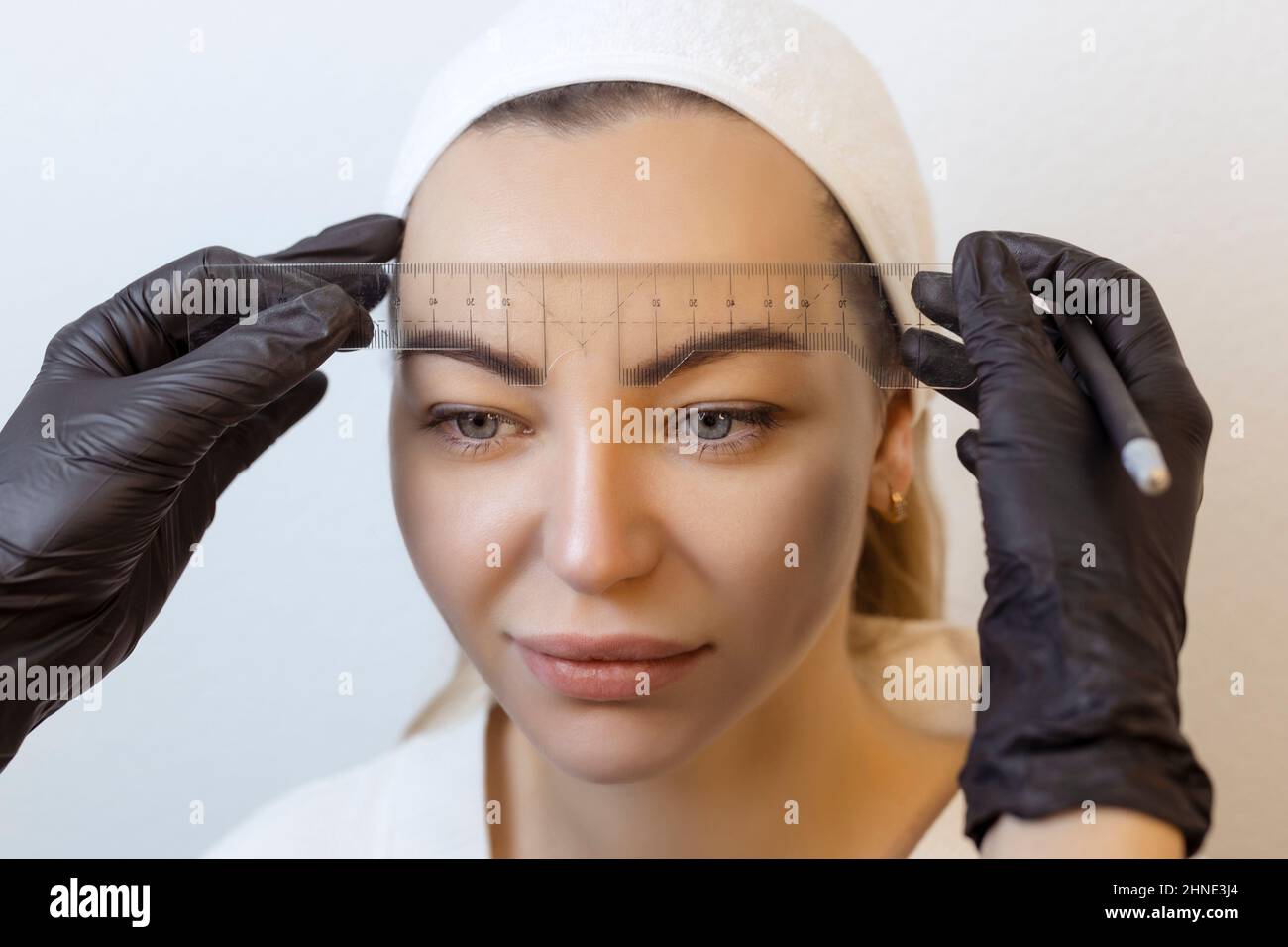 Tatouage de sourcil .permanent masque de maquillage de sourcil applique le contour avec règle sur le sourcil du client Banque D'Images