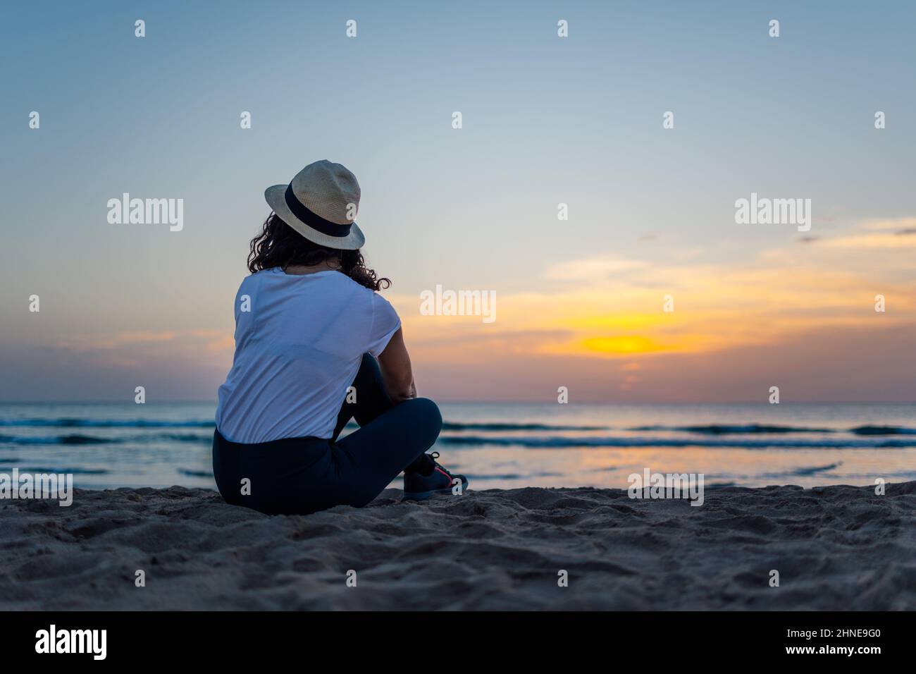 Jeune femme profitant du beau coucher de soleil sur la mer Banque D'Images