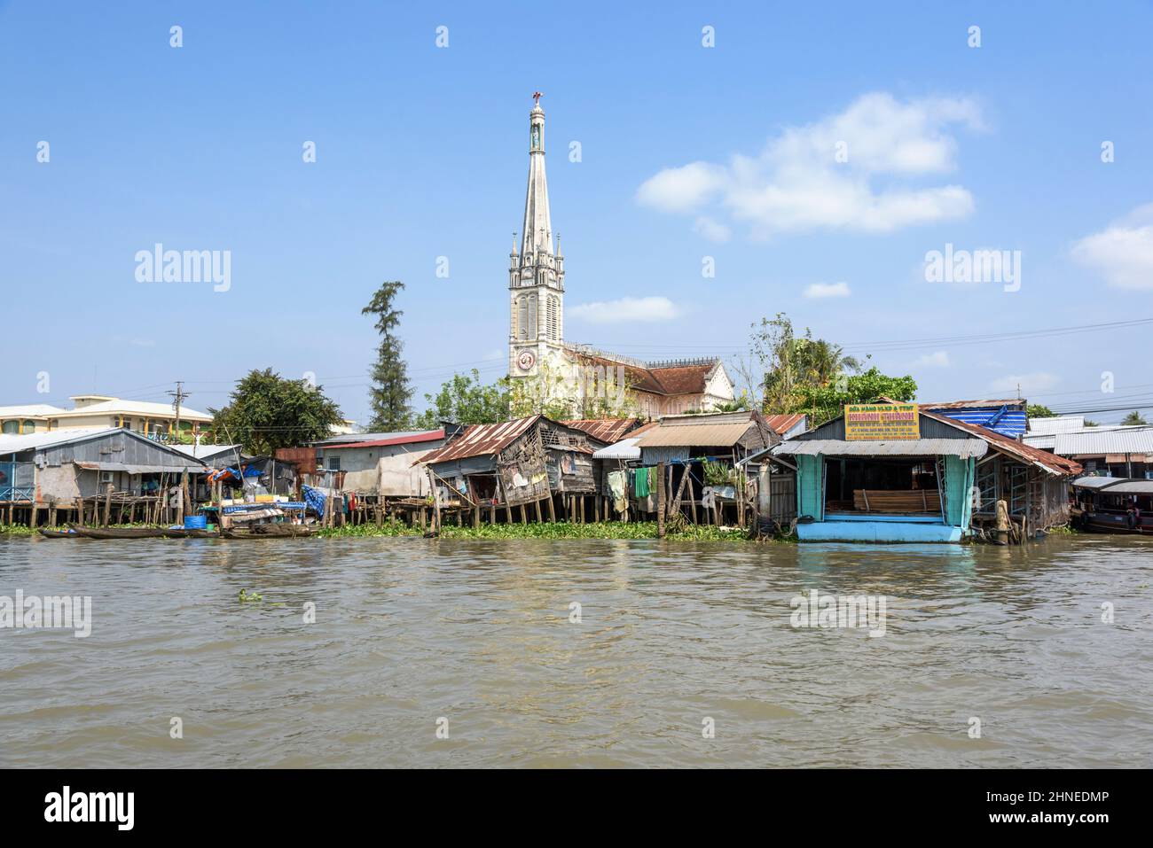Église en bord de rivière et maisons sur pilotis en bois sur le Mékong à Cai be, province de Tien Giang, delta du Mékong, sud du Vietnam, Asie du Sud-est Banque D'Images