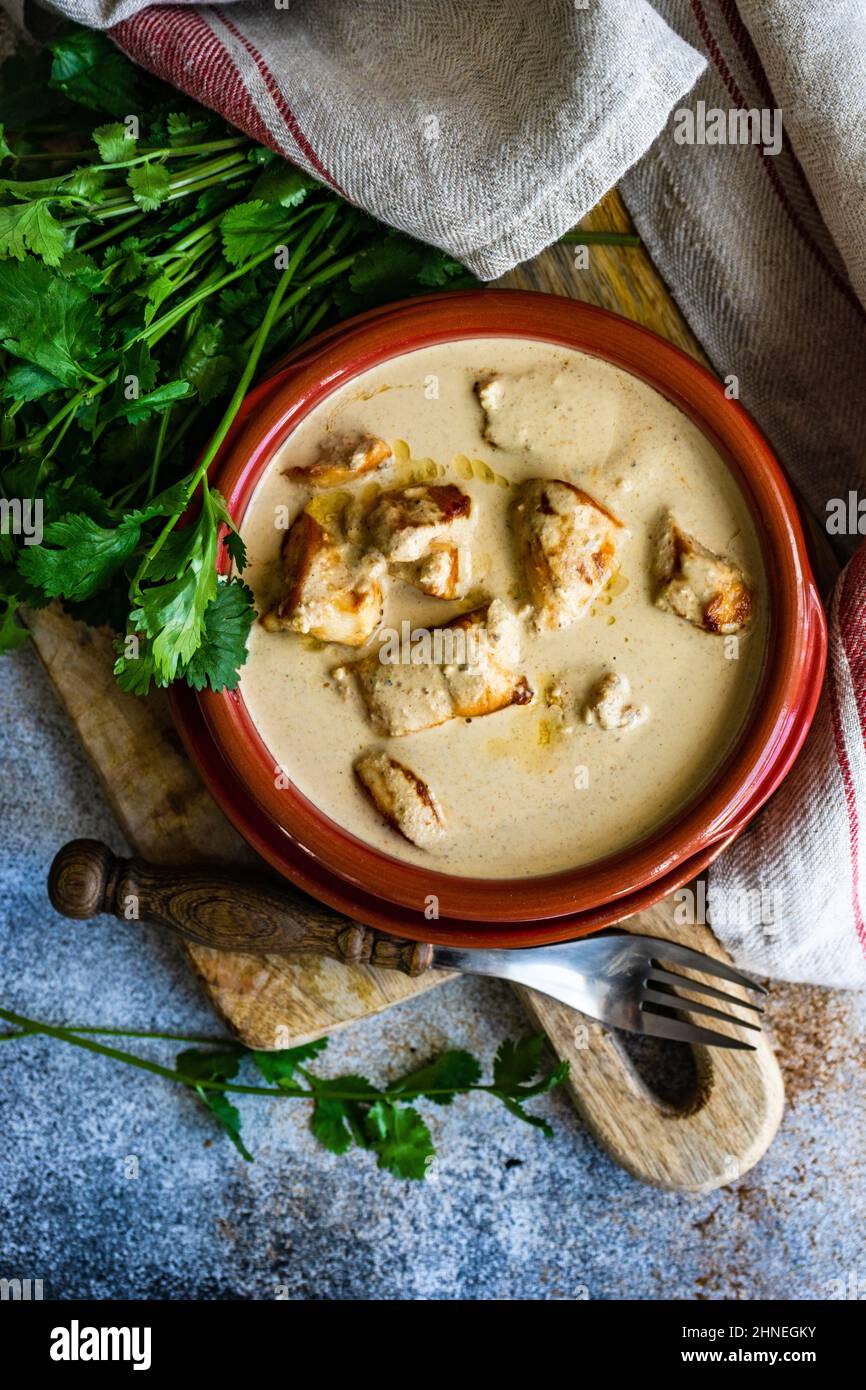 Vue en hauteur d'un bol de poulet géorgien à la sauce aux noix (poulet Bazhe) et à la coriandre Banque D'Images