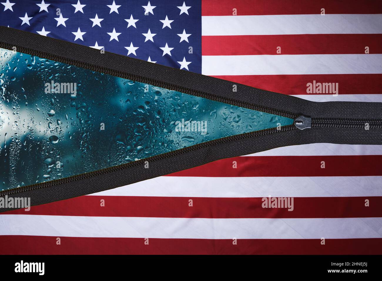 Drapeau des Etats-Unis avec une fermeture éclair sans bouton et un fond avec temps pluvieux et des nuages derrière le verre Banque D'Images
