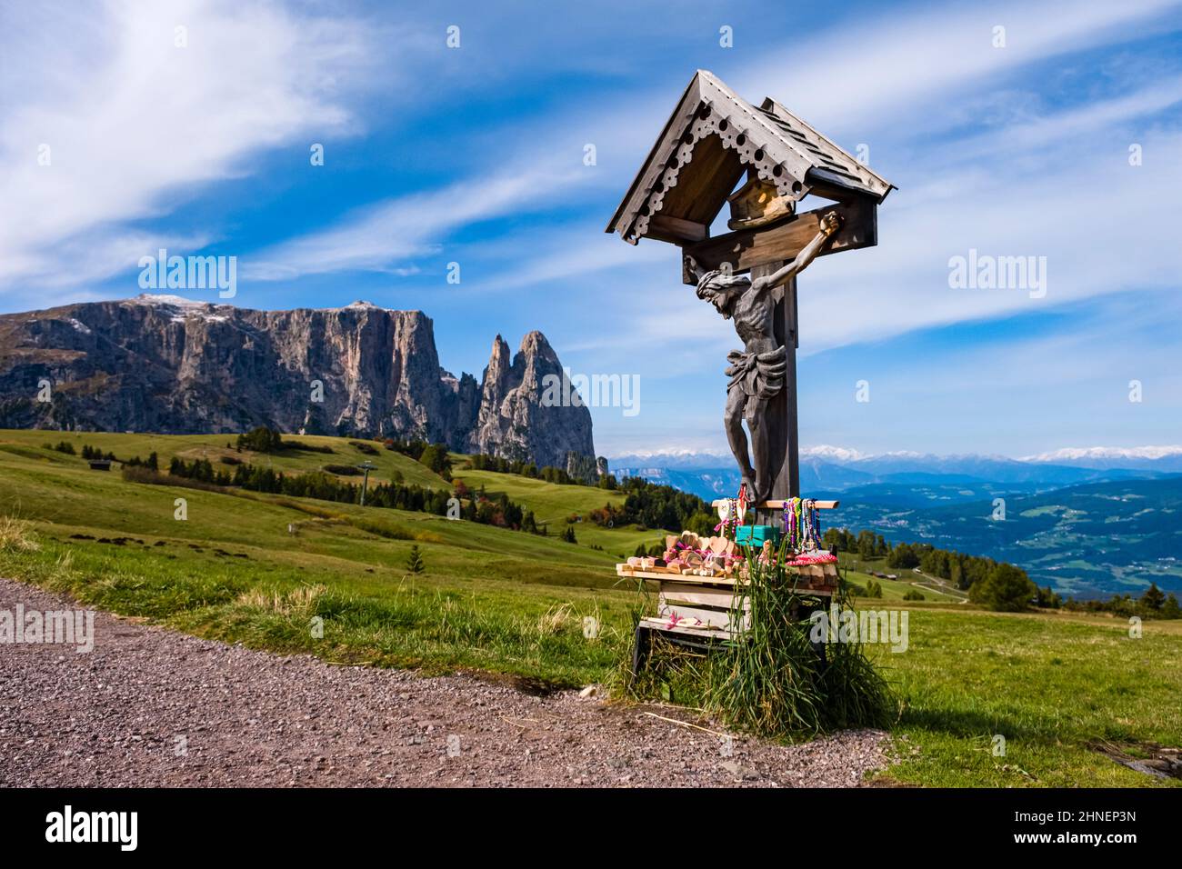 Campagne agricole vallonnée avec pâturages et crucifix à Seiser Alm, le groupe Schlern avec Monte Petz (à gauche) et Santnerspitze (à droite). Banque D'Images