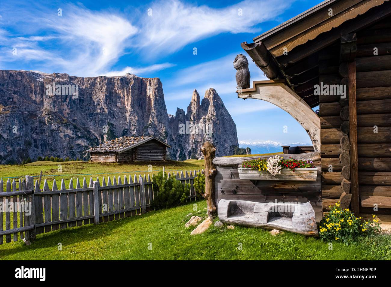 Campagne agricole vallonnée avec des huttes en bois à Seiser Alm, le groupe Schlern avec Monte Petz (à gauche) et Santnerspitze (à droite) au loin. Banque D'Images