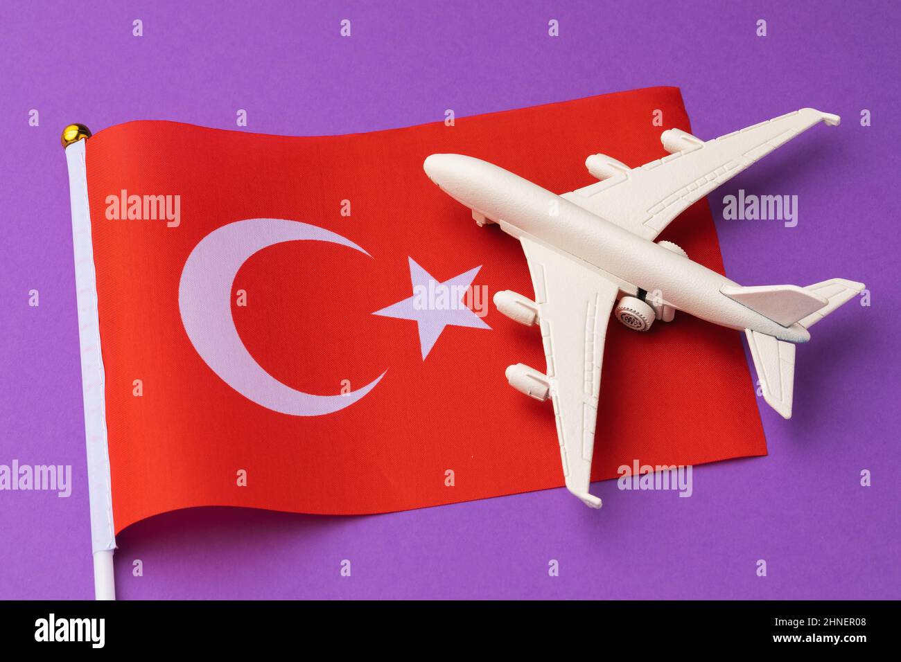 Drapeau turc et avion jouet sur un fond coloré, un concept sur le thème du voyage en Turquie Banque D'Images