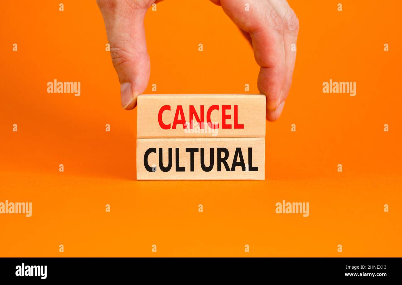 Annuler le symbole culturel. Concept mots Annuler culturel sur des blocs de bois sur une belle table orange fond orange. Main d'homme d'affaires. Business et c Banque D'Images