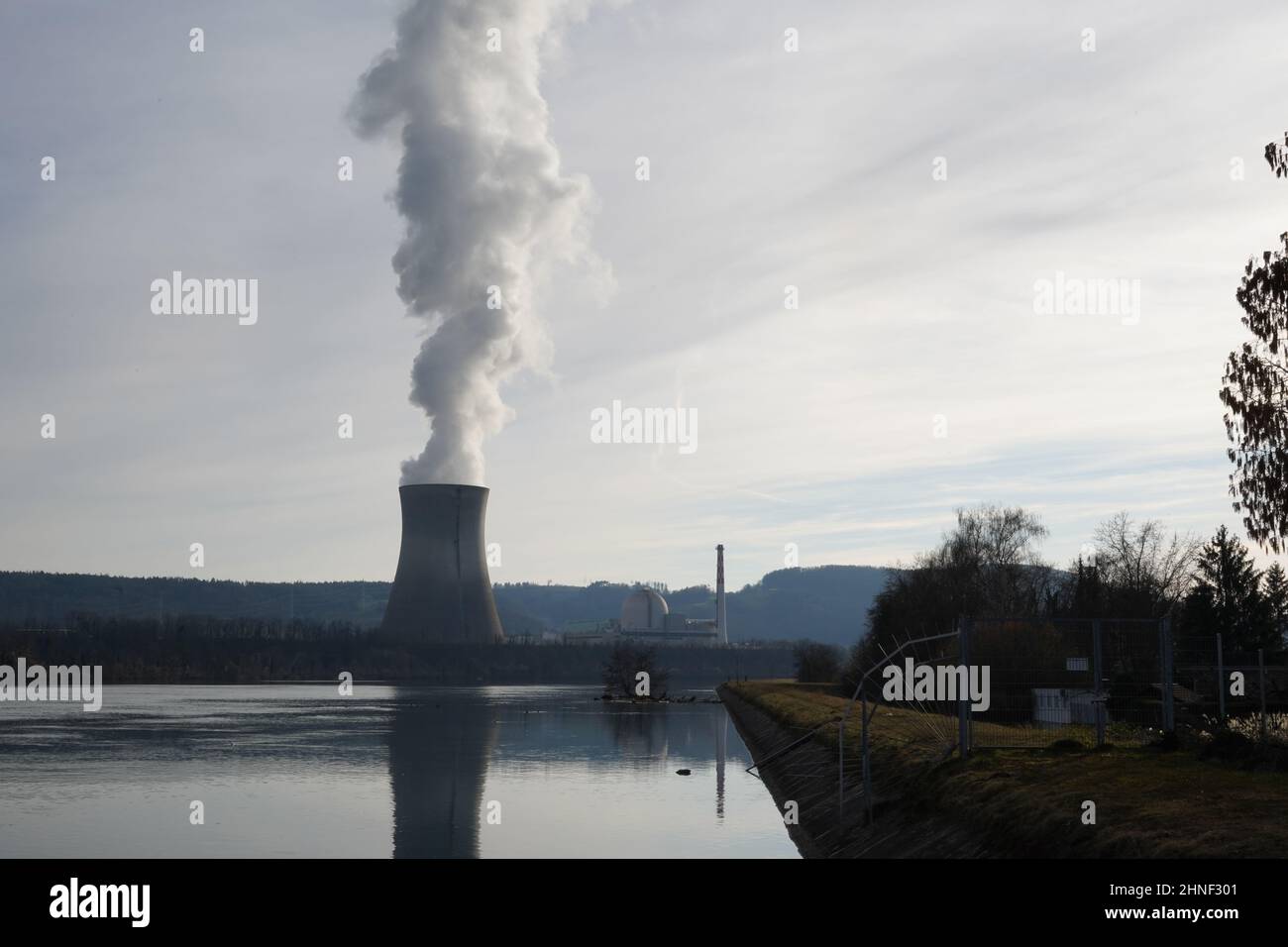 Centrale nucléaire sur la rive du Rhin. De la fumée s'échappe de la tour de refroidissement. Banque D'Images