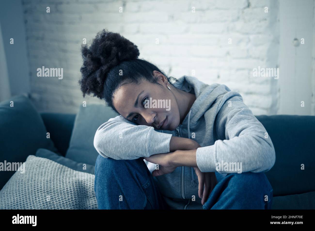 Déprimé jeune femme afro-américaine attrayante couché sur un canapé à la maison se sentant triste fatigué et inquiet souffrant de dépression stress et d'anxiété à menta Banque D'Images