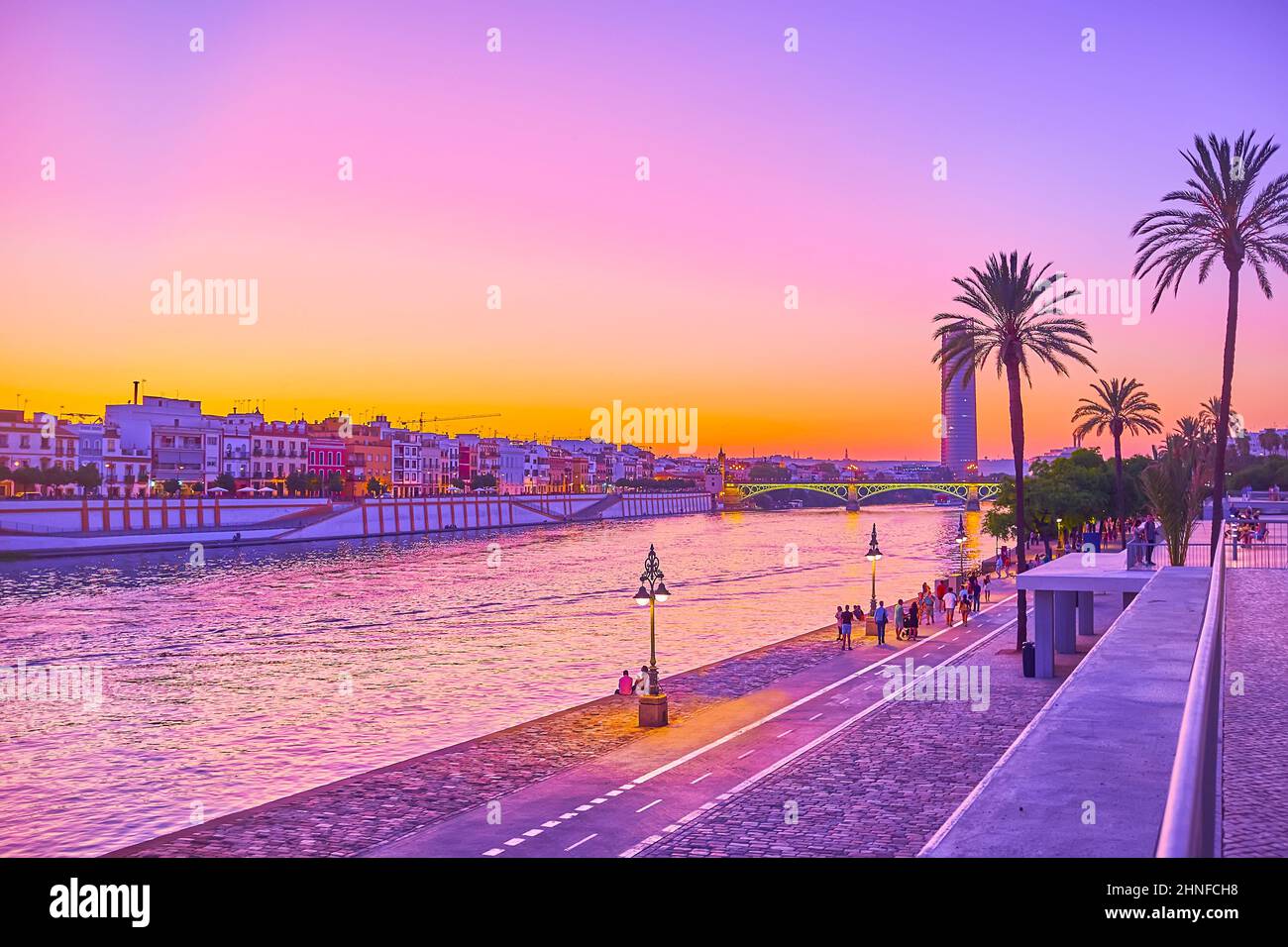 SÉVILLE, ESPAGNE - 29 SEPTEMBRE 2019 : le crépuscule violet au-dessus du fleuve Guadalquivir avec silhouettes de palmiers, Torre Sevilla et le vieux quartier de Triana Banque D'Images