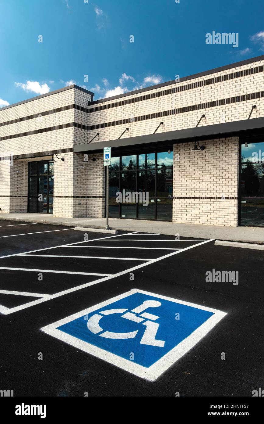 Photo verticale d'un panneau de stationnement pour handicapés peint dans une place de stationnement pour handicapés dans un nouveau centre commercial en construction. Banque D'Images