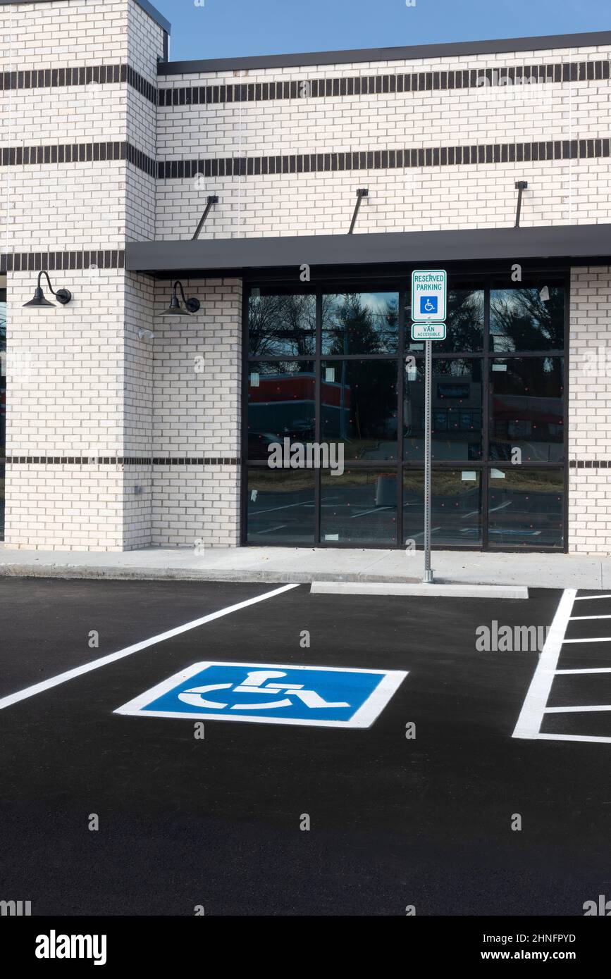 Plan vertical d'une place de stationnement pour handicapés devant une nouvelle construction de vente au détail. Banque D'Images