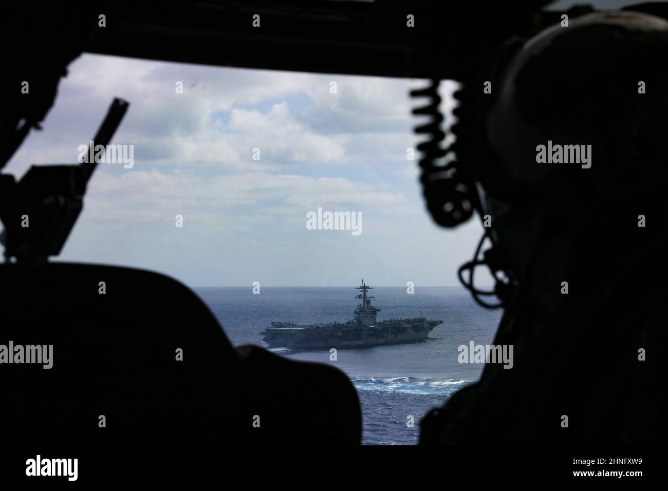 MER DES PHILIPPINES (fév 15, 2022) le lieutenant de la marine américaine Sarrah Childress, un pilote avec les “Chargers” de l’Escadron de combat en mer (HSC) 14, vole un hélicoptère MH-60s Sea Hawk, affecté à HSC-14, vers le porte-avions de la classe Nimitz USS Abraham Lincoln (CVN 72) à l’appui de l’exercice Jungle Warfare 22 (JWX 22) à travers Okinawa, au Japon. JWX 22 est un exercice de formation sur le terrain à grande échelle axé sur l'exploitation des capacités intégrées des partenaires conjoints et alliés afin de renforcer la sensibilisation, la manœuvre et les incendies de tous les domaines dans un environnement maritime distribué. (É.-U. Navy photo par communication de masse Banque D'Images