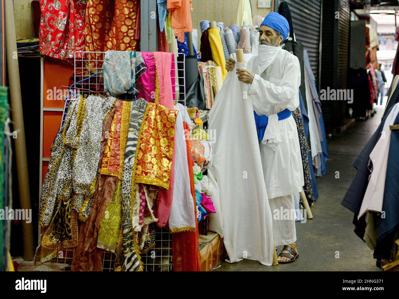 Bangkok, Thaïlande. 15th févr. 2022. Un vendeur indien Sikh ajuste les textiles dans Little India, Phahuran Market dans le centre-ville de Bangkok.le secteur est à 5 minutes à pied du quartier chinois de Bangkok et se vante de l'économie d'une grande communauté Sikh du nord-ouest. Crédit : SOPA Images Limited/Alamy Live News Banque D'Images