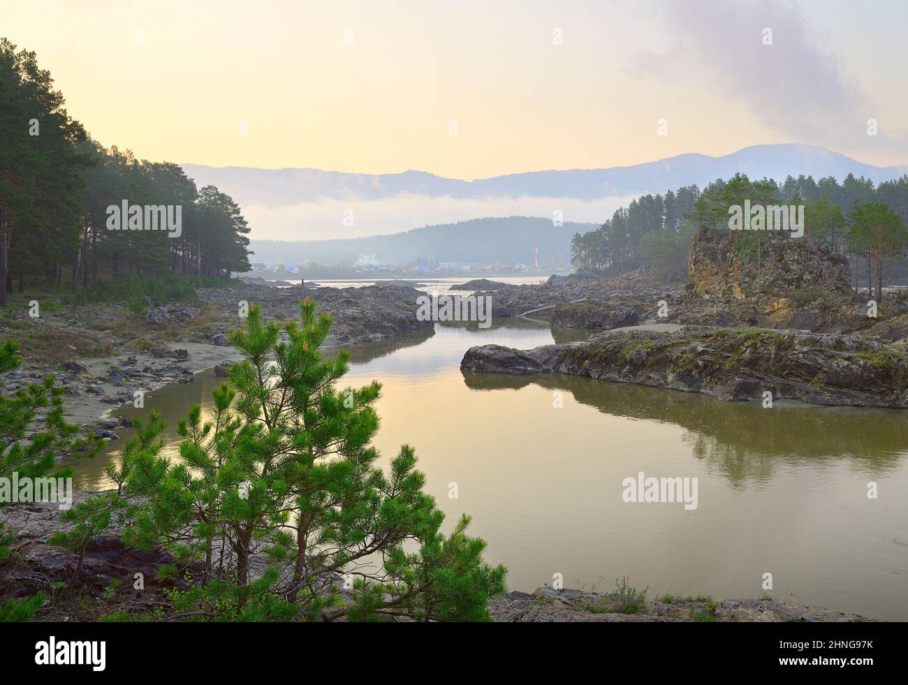 Les rapides de Manzherok dans les montagnes de l'Altaï. Dawn au-dessus de la rive rocheuse de la rivière Katun, pins sur les rochers, le village de Manzherok et les montagnes Banque D'Images