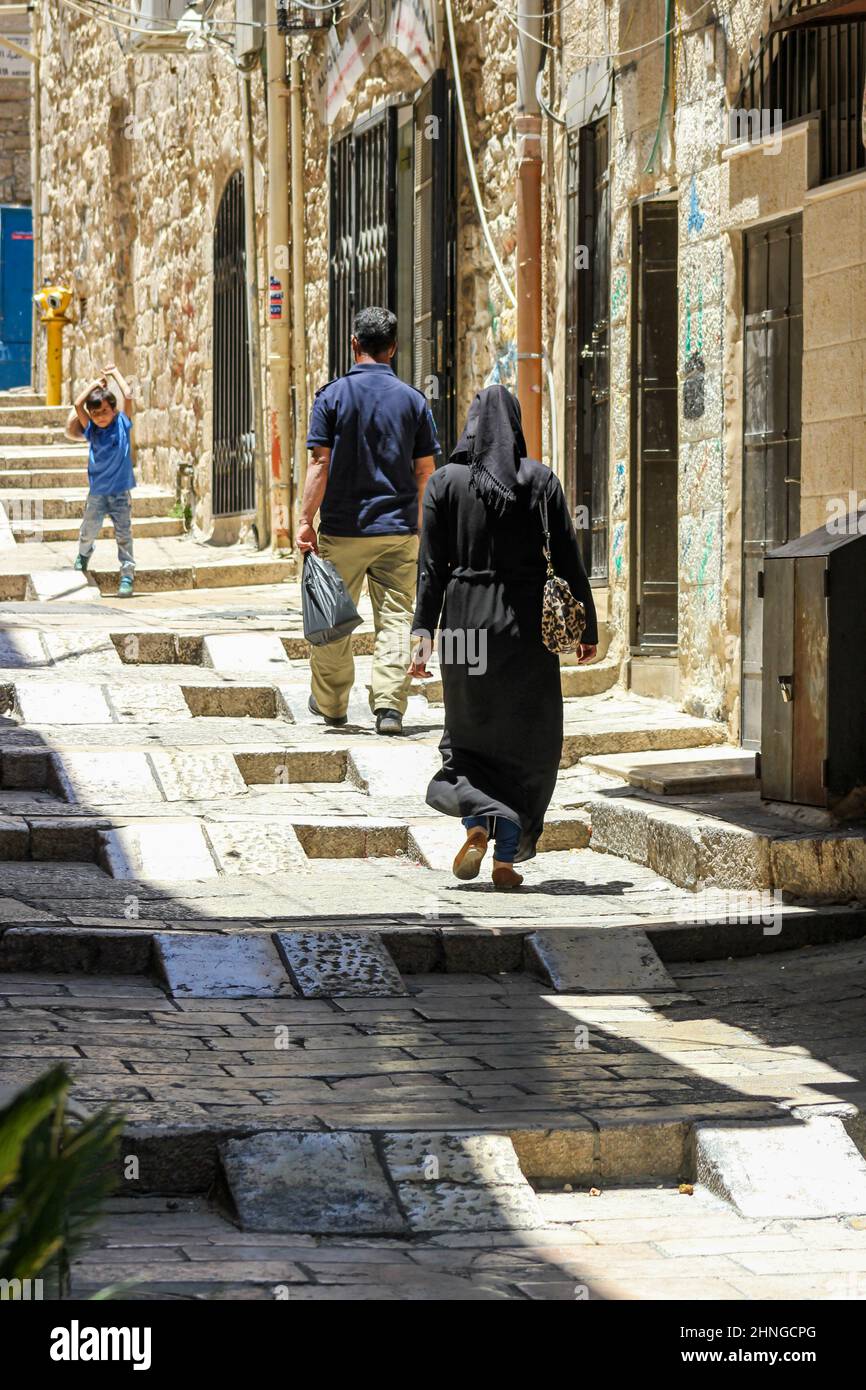 Une famille marche les marches accessibles dans une allée de la vieille ville de Jérusalem, Israël. Banque D'Images