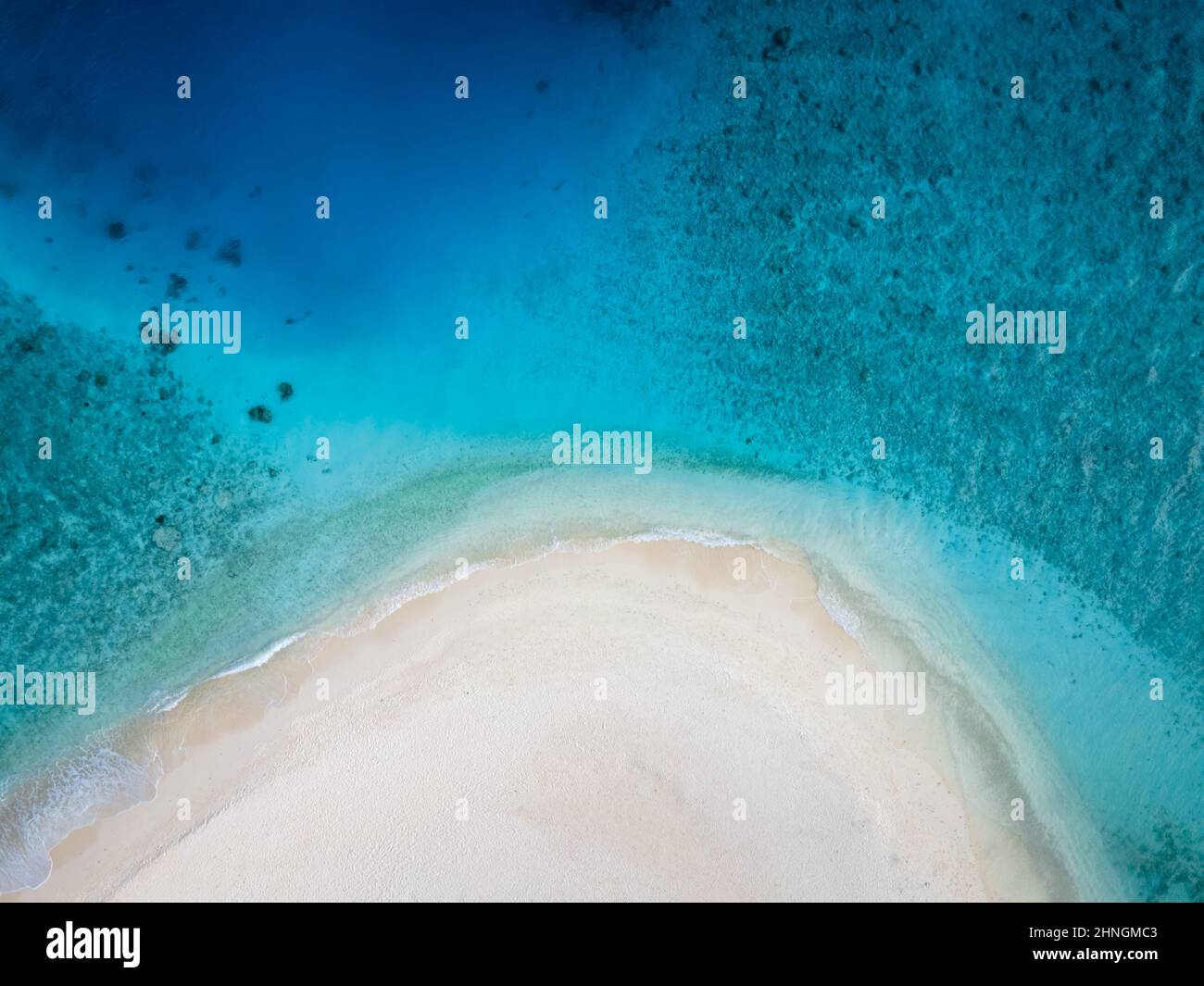 Plage parfaite pour des vacances avec sable blanc et bleu turquoise transparent. Vue aérienne du haut vers le bas depuis le drone. Une île tropicale immaculée Banque D'Images