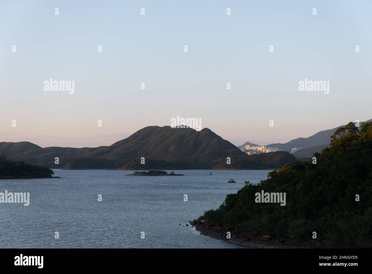 Paysage de montagnes sur les îles avec lumière du soleil réfléchie de la surface de l'eau au coucher du soleil Banque D'Images