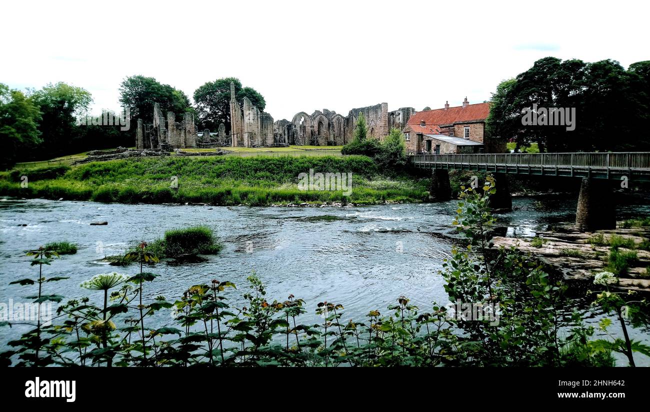Prieuré de Finchale, prieuré prononcé de finkle, également connu sous le nom de Abbaye de Finchale, comté de Durham, Royaume-Uni avec son pont-bascule sur l'usure de la rivière. Comme beaucoup d'abbayes anglais, il se trouve dans un cadre boisé magnifique. Le bâtiment bénédictin fut fondé en 1196 sur le site de l'ermitage de St Godric, un marin et marchand à la retraite, le prieuré devint un avant-poste de la cathédrale de Durham d'où les moines de Durham voyageaient et l'utilisaient comme retraite de vacances jusqu'à sa suppression en 1538. L'ermitage original de Godric a été dédié à Saint Jean-Baptiste. Il est sous la garde du patrimoine anglais. Banque D'Images